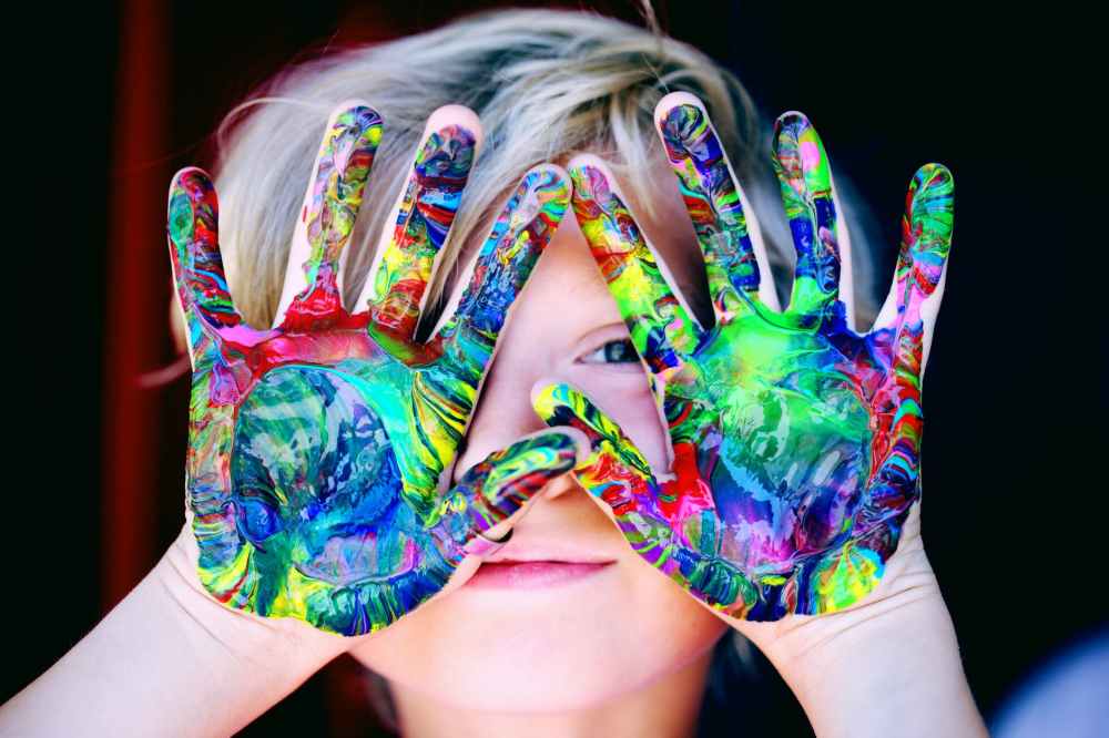 Esquema infantil de envolvimiento - niño con manos envueltas en pintura